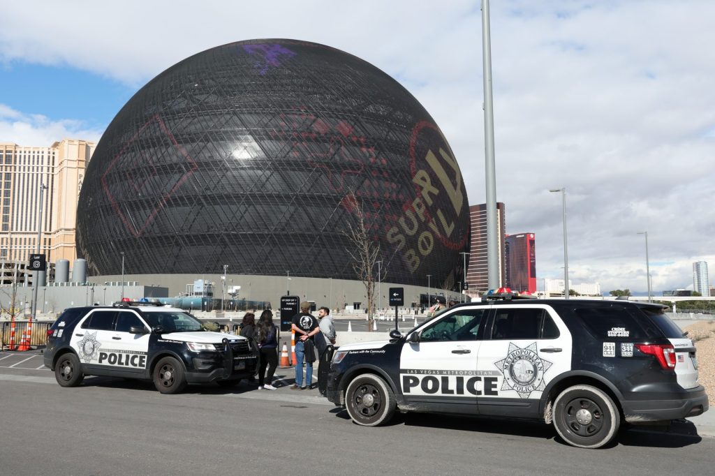LAS VEGAS, NEVADA - FEBRUARY 07: Individuals are seen in handcuffs near the Sphere after law enforcement responded to reports that pro-life activist Maison DesChamps (not pictured) had climbed to the top of the structure on February 07, 2024 in Las Vegas, Nevada. DesChamps was previously arrested for also climbing the Aria in August 2021.