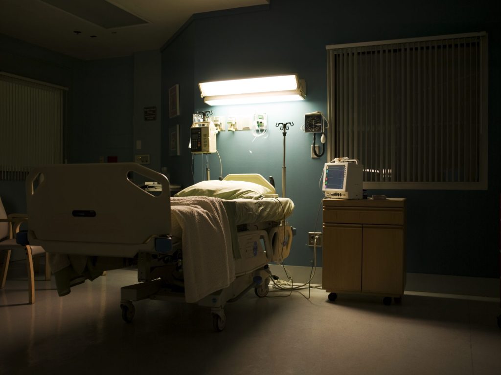 Bed in darkened empty hospital room